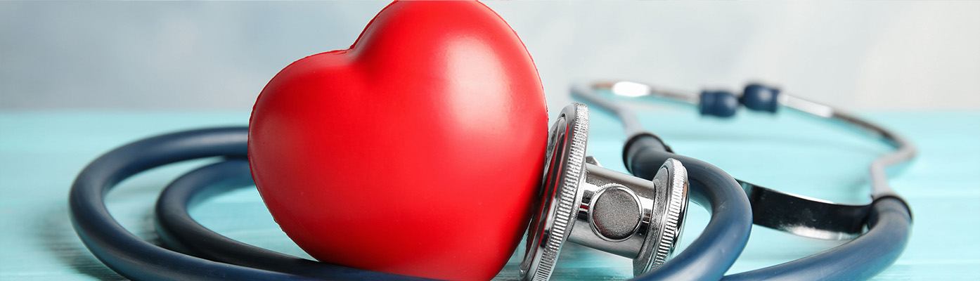Stethoscope and red heart on wooden table
