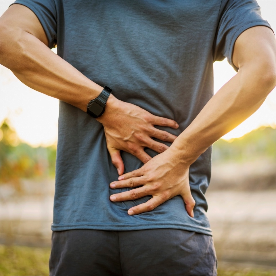 Back pain, close up young man has injury during outdoor exercise