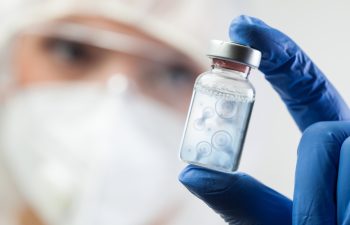 Cell division process conceptual illustration,lab scientist holding ampoule vial with cell nucleus molecules splitting,DNA replication procedure,mitosis daughter from parent chromosome cell production