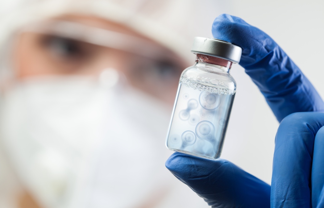 Cell division process conceptual illustration,lab scientist holding ampoule vial with cell nucleus molecules splitting,DNA replication procedure,mitosis daughter from parent chromosome cell production