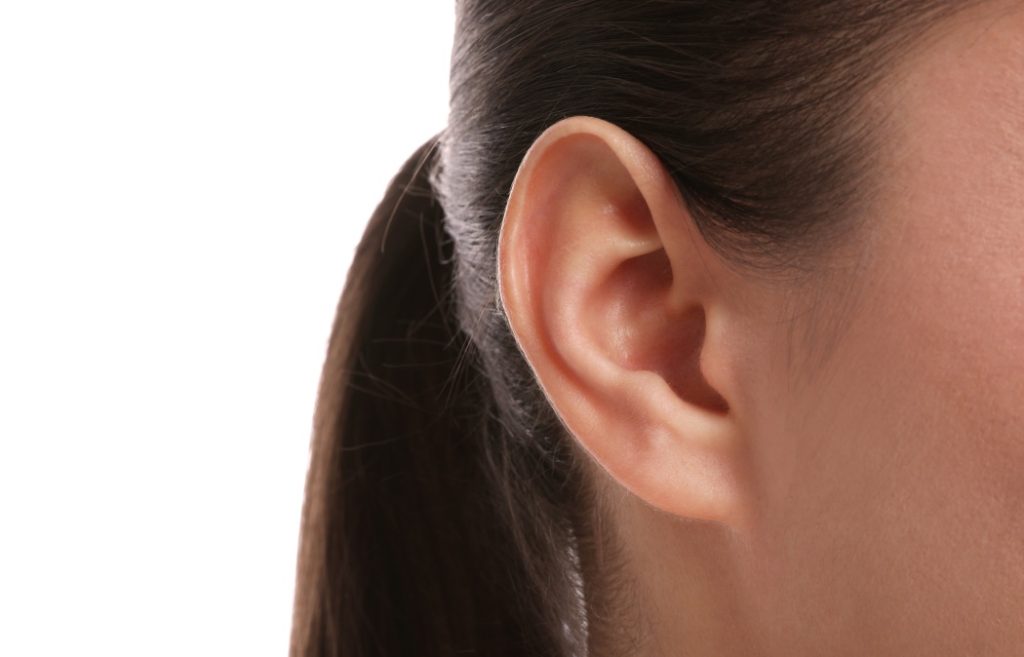 Woman on white background, closeup of ear