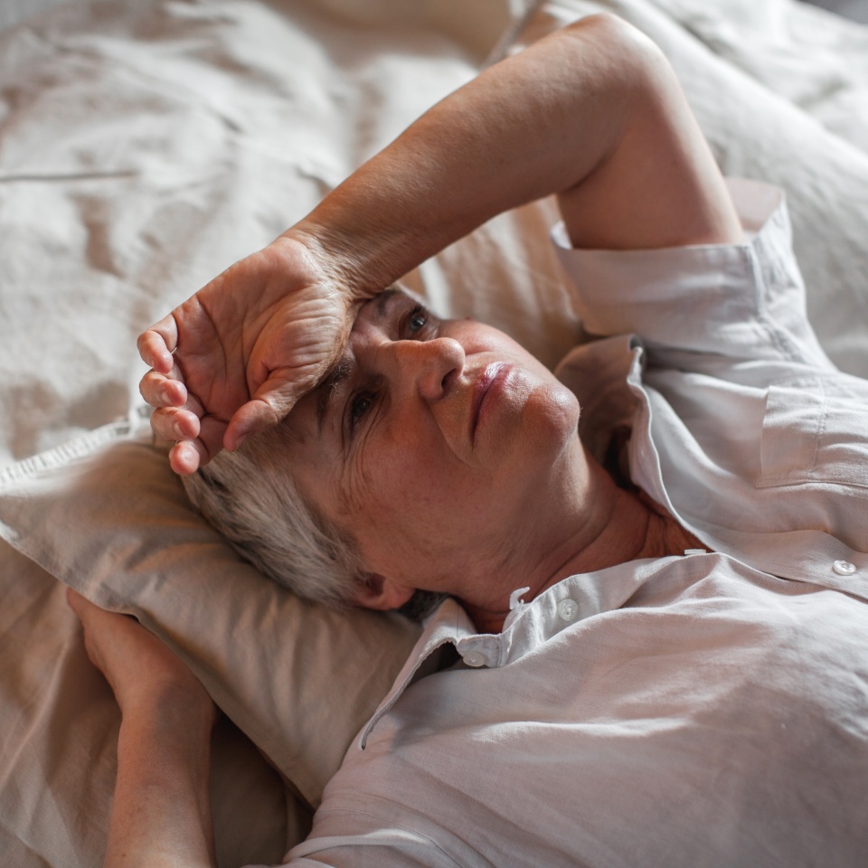 Unhappy elderly woman lying in bed at home thinking pondering over life problems, mourning or yearning, upset sad senior female relax in bedroom feel unwell or stressed suffering from insomnia