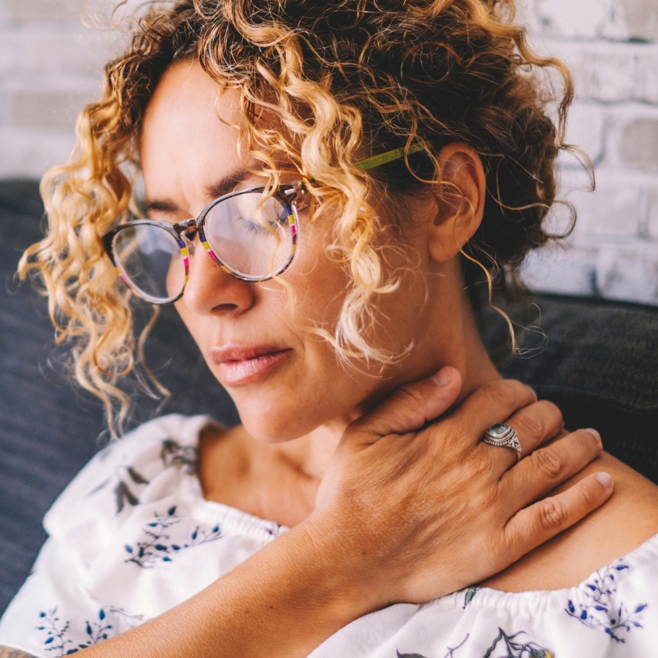 Sick middle age adult young women touching the neck have shoulder and neck pain.Healthcare and medicine concept. Female people suffering shoulder disease at home sitting on the sofa