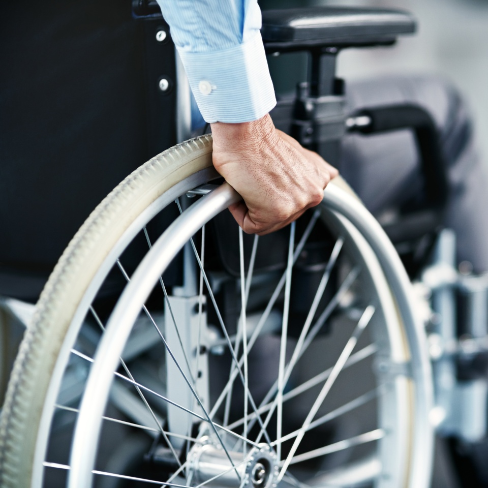 Wheelchair, disability and man hand holding wheel in a hospital for healthcare. Disabled, mobility problem and male person in a clinic for support and medical care with hands of patient and mockup