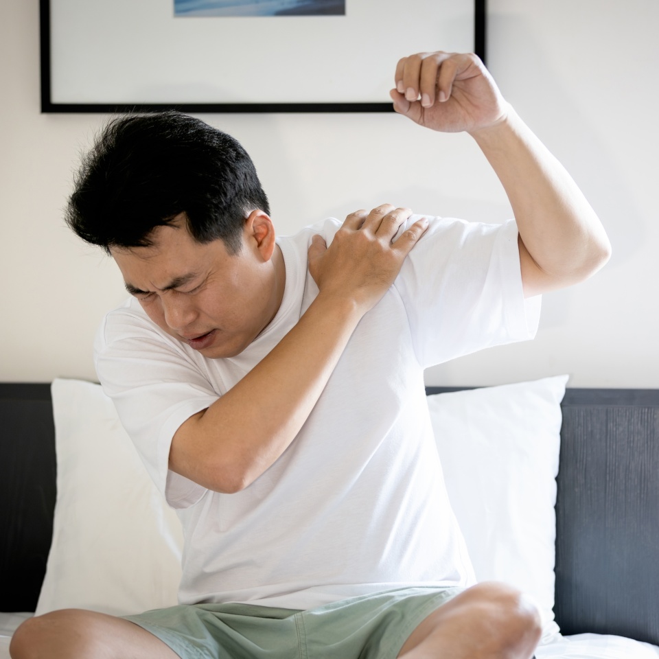 Asian middle aged man suffering from frozen shoulder,pain and stiffness,unable to move,difficulty lifting his arm,male people with calcific tendonitis or shoulder injuries,health care,medical concept
