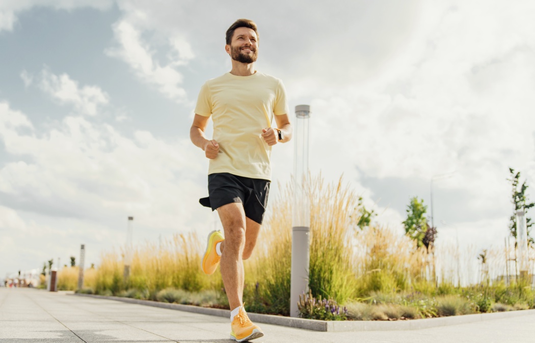 Man running on a sunny day in urban park, fitness and healthy lifestyle concept.