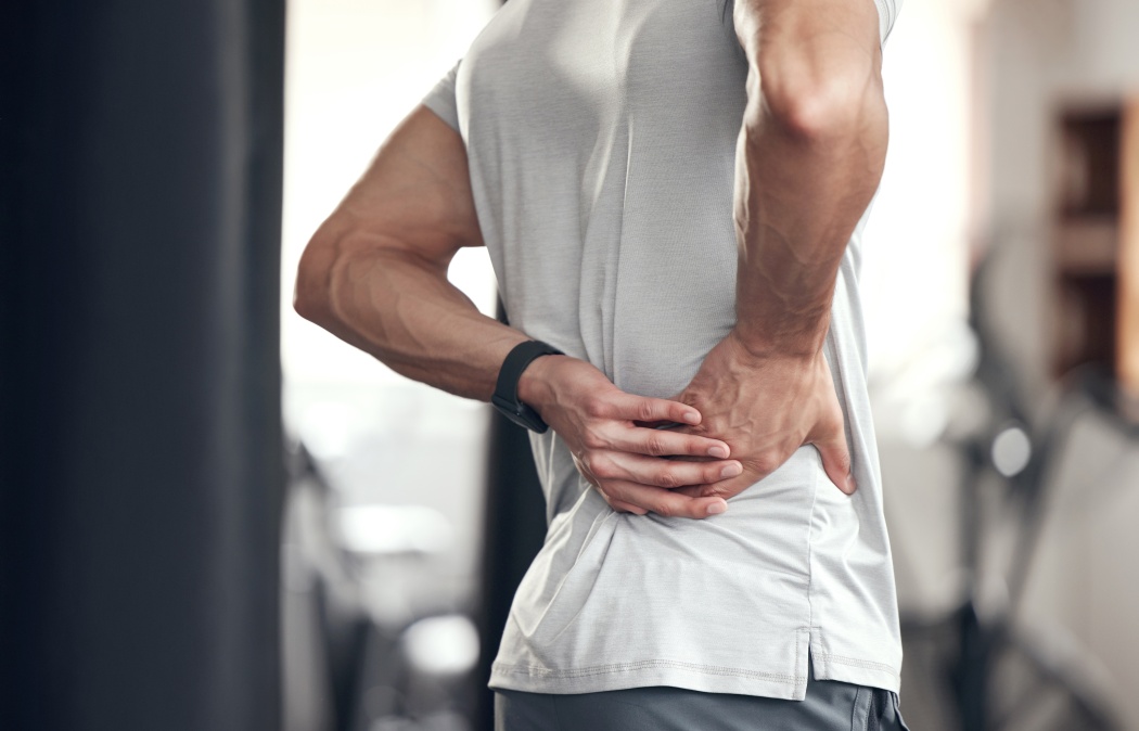 Hip pain, man and fitness injury at gym for boxing, sport and training with accident at health center. Wellness, hands and exercise of an athlete with hurt joint and scoliosis concern of spine