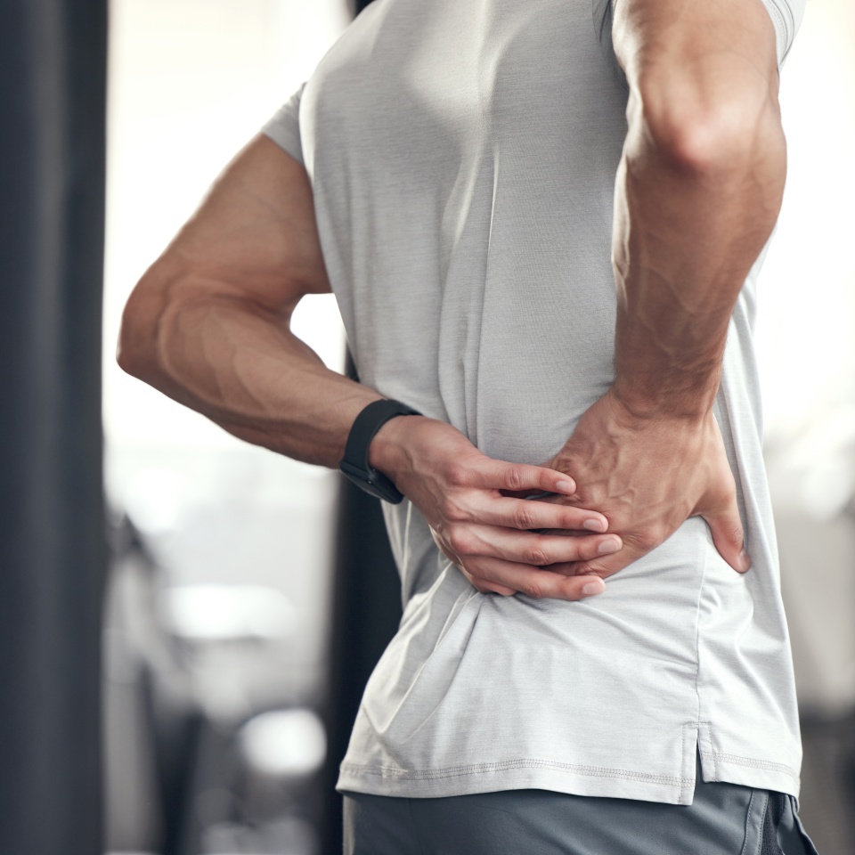 Hip pain, man and fitness injury at gym for boxing, sport and training with accident at health center. Wellness, hands and exercise of an athlete with hurt joint and scoliosis concern of spine