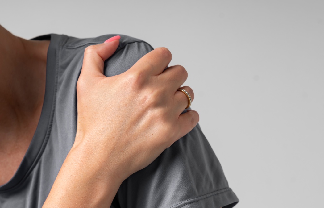 Close-up portrait of young woman suffering from shoulder pain