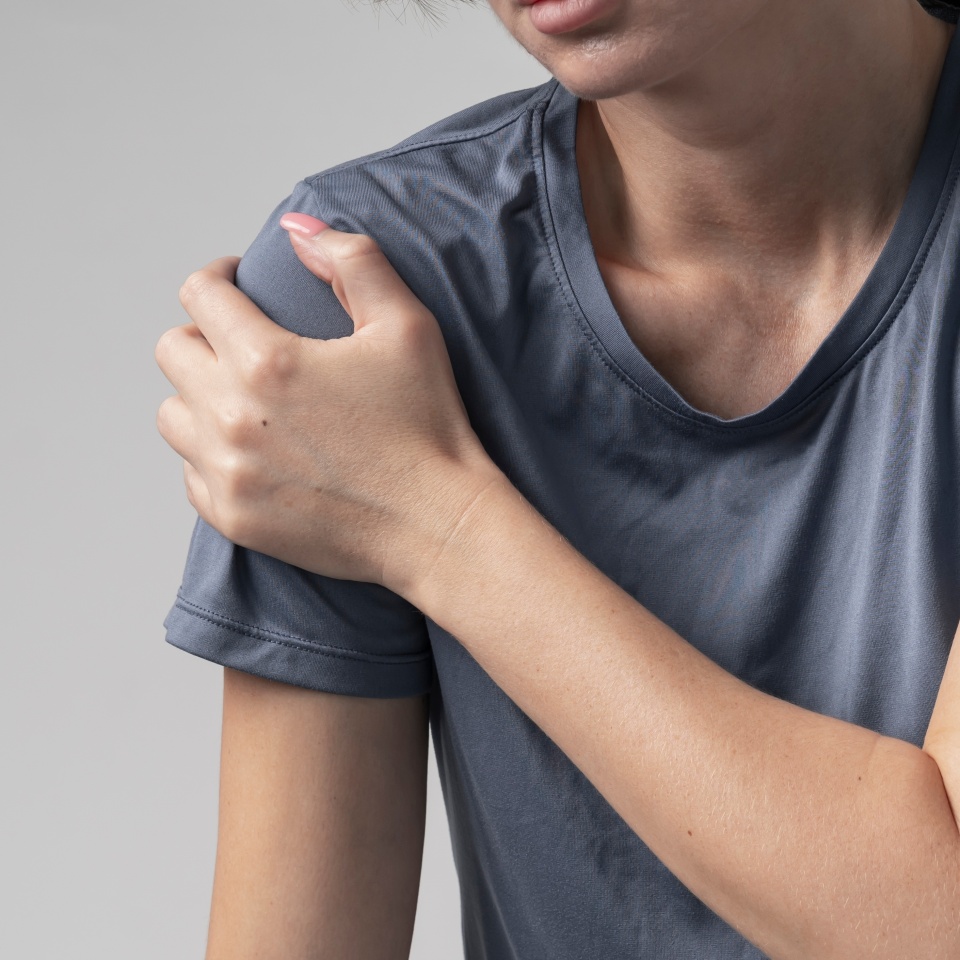 Close-up portrait of young woman suffering from shoulder pain