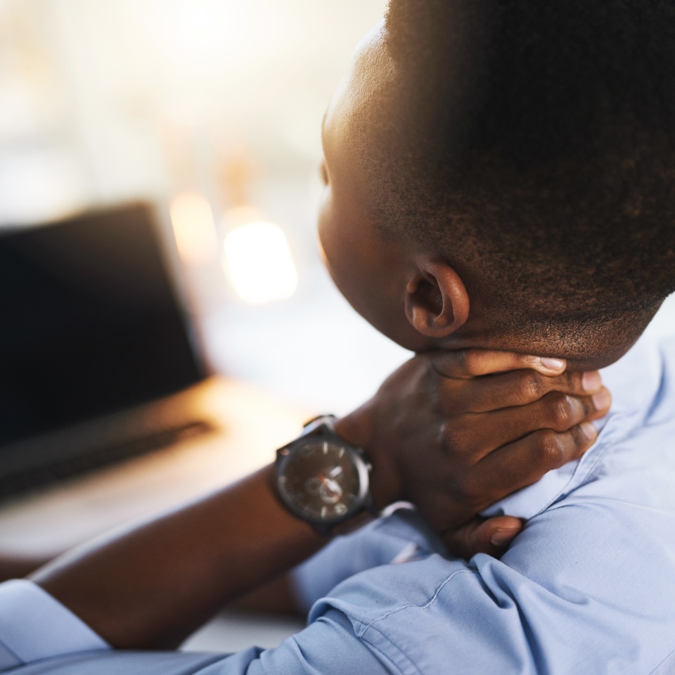 Office, stress and black man at laptop with neck pain, fatigue and business burnout from back. Posture, ergonomics and tired businessman with muscle cramps, injury and overworked at digital agency