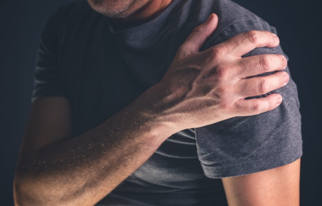 Aching frozen shoulder pain as symptom of rotator cuff tendinitis, adult caucasian male suffering from chronic bursitis, selective focus