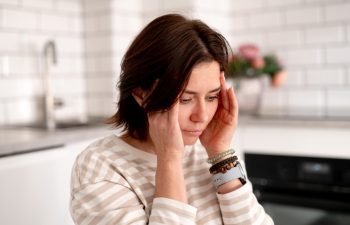 Woman Holds Temples Suffering From Headache