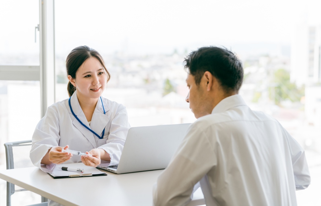 Doctor explaining injections, doctor and middle-aged male patient (self-injection, syringe, insulin)