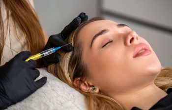 Hair strengthen and growth, needle mesotherapy. Woman getting cosmetics injection in head, copy space. Young woman with hair loss problem receiving injection. Hair loss, alopecia treatment, prp.