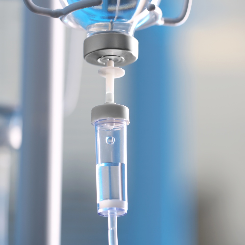 IV drip chamber against blurred light background