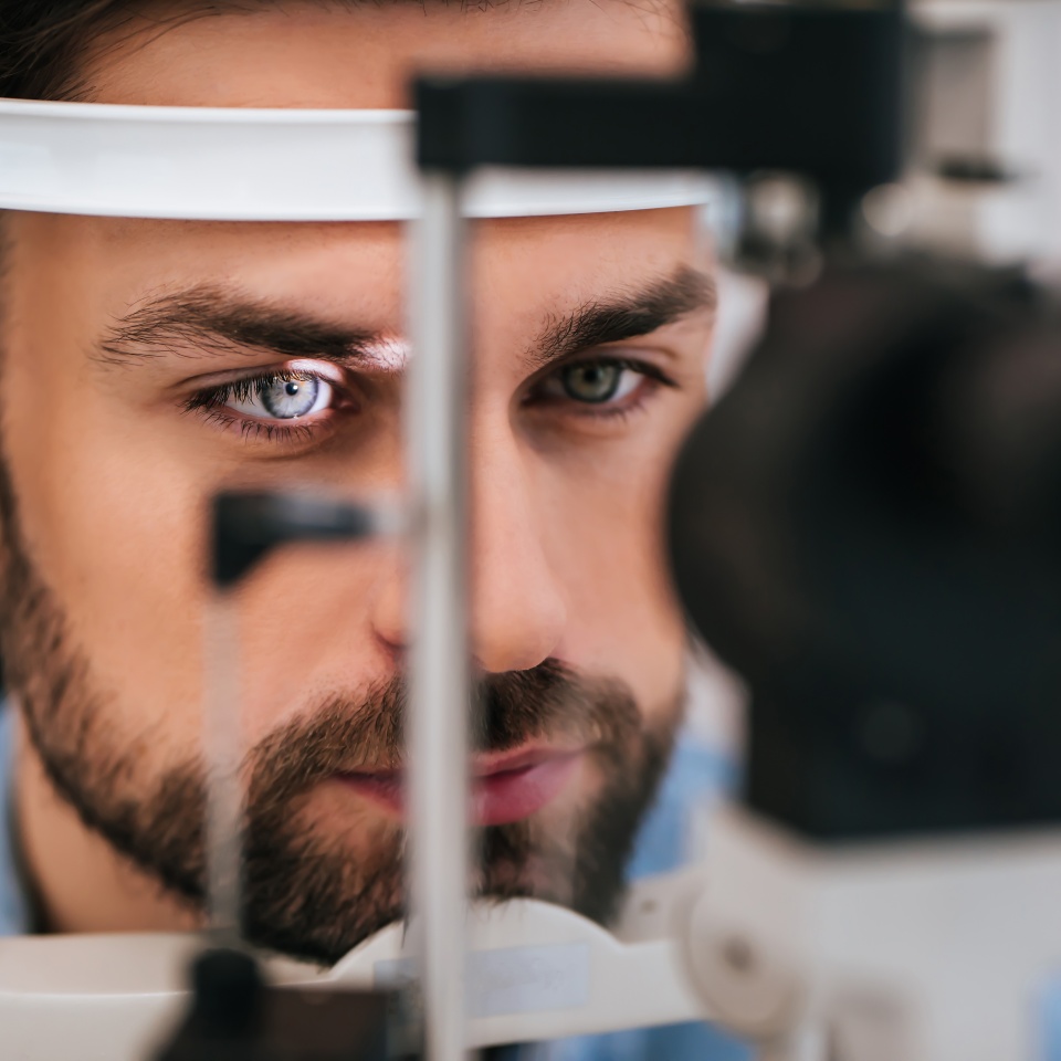 Handsome young man is checking the eye vision in modern ophthalmology clinic. Patient in ophthalmology clinic