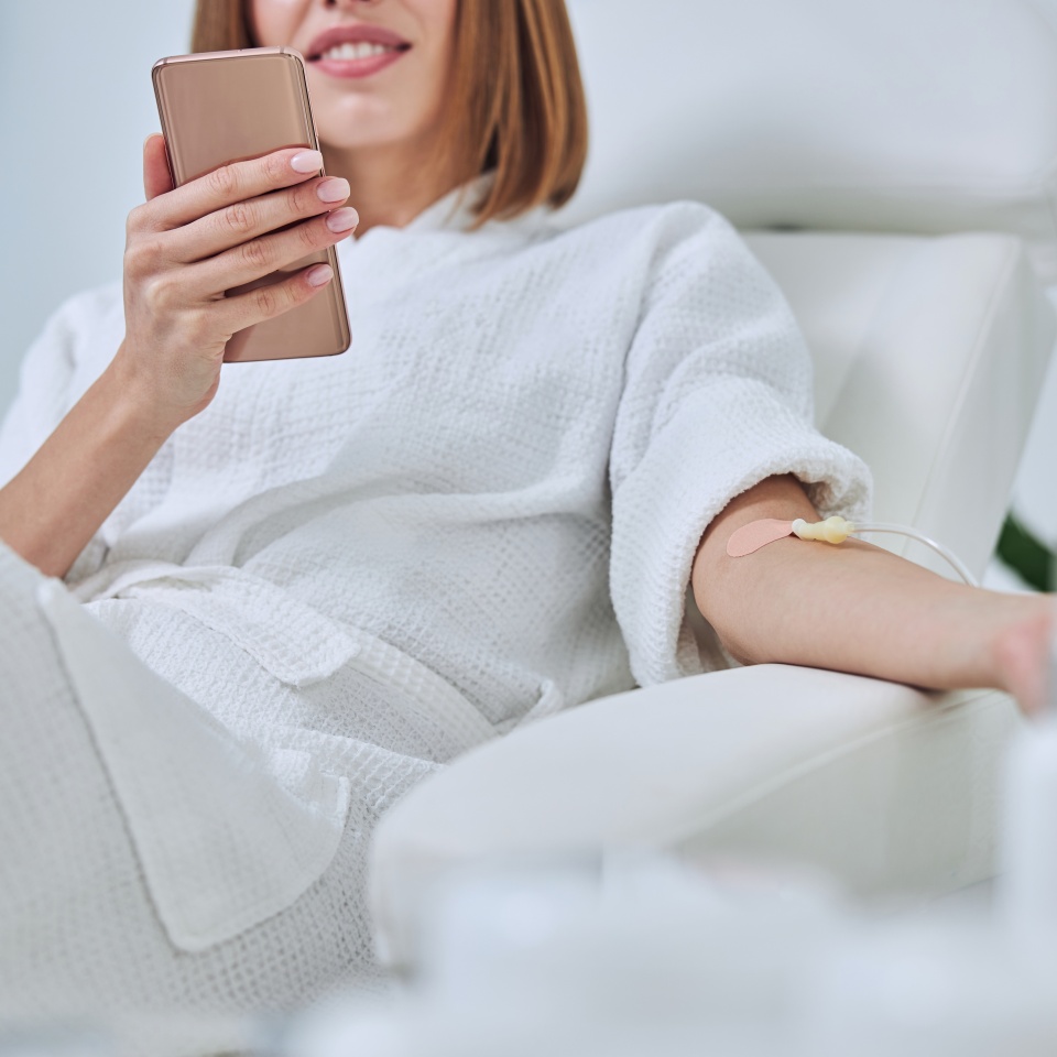 Beautiful Caucasian woman sitting in armchair during medicine procedure in spa salon