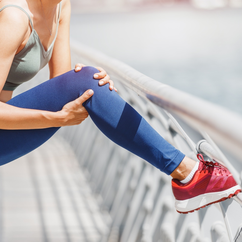 Young woman was running along the embankment and suddenly felt a sharp pain in the knee joint due to a dislocation or rupture of the meniscus