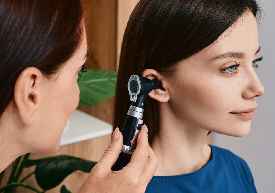 Hearing check-up, otoscopy. Adult woman while ear test with audiologist at medical office. Diagnosis of hear impairment