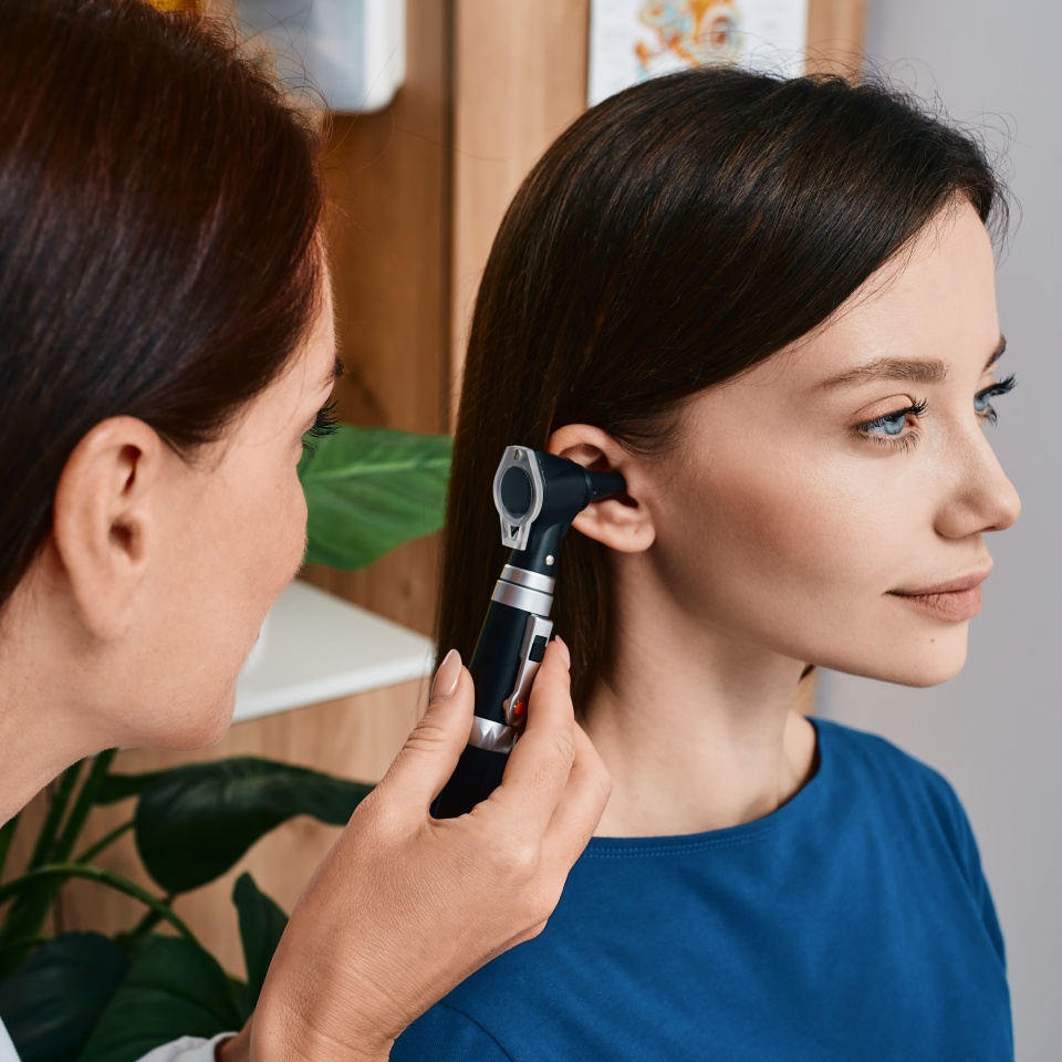 Hearing check-up, otoscopy. Adult woman while ear test with audiologist at medical office. Diagnosis of hear impairment