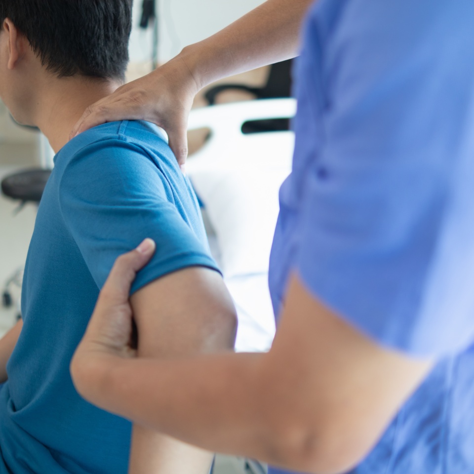 man was admitted for treatment of muscle pain in back of his shoulder due to working hard and causing muscle inflammation. doctor is treating man muscle pain in his back and shoulders due to overwork.