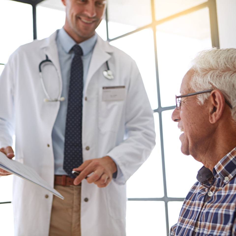Doctor, old man and clipboard for paperwork, consultation and happy for good news, review or report. Medic, elderly patient and checklist for documentation, exam and information for health in clinic
