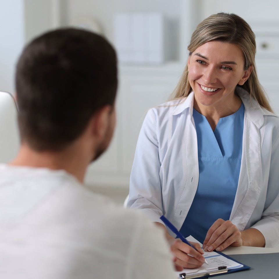 Professional doctor working with patient at white table in hospital