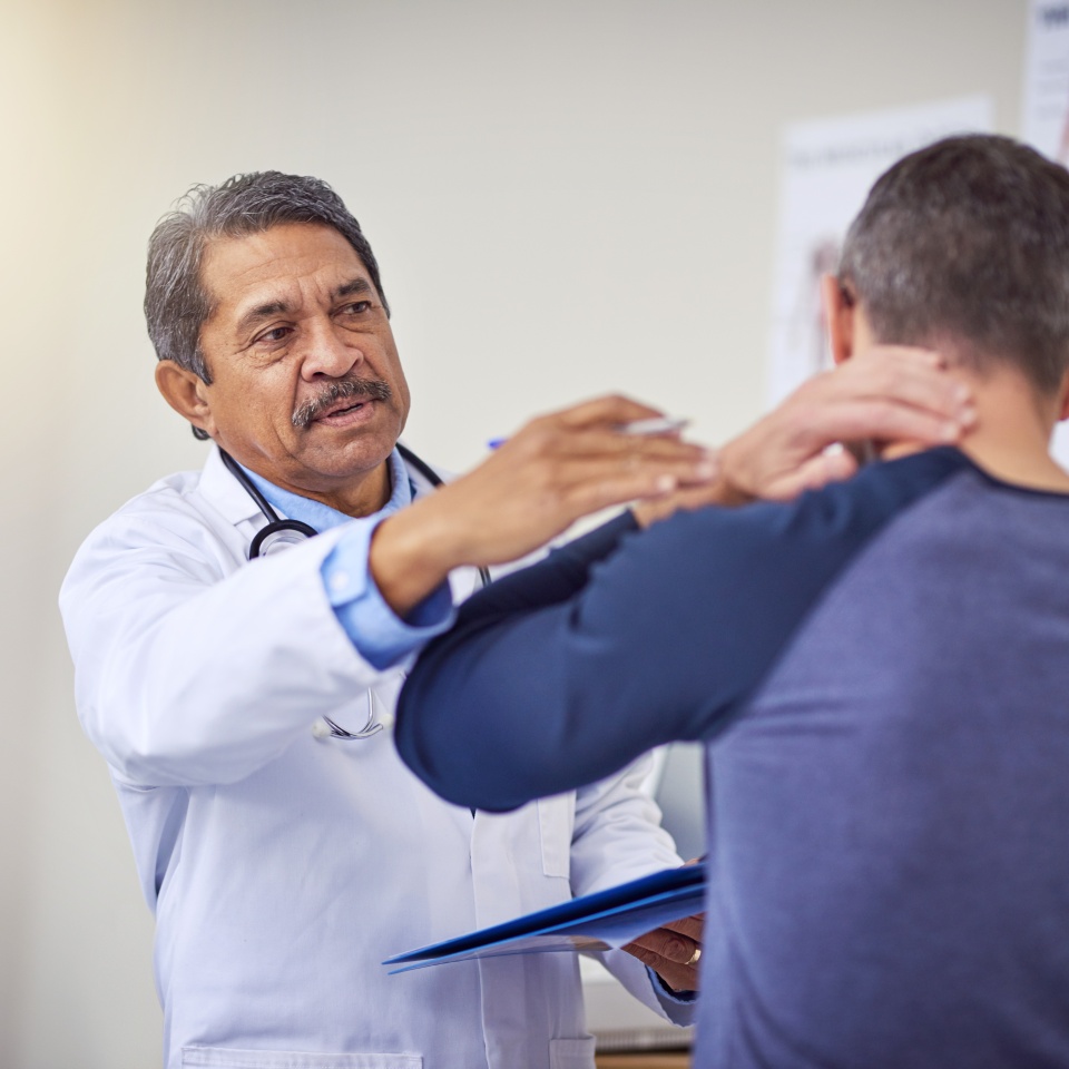 Man, doctor and patient with neck injury for consultation, pain or checkup at hospital. Male person, medical professional and client with sore spine, spasm or ache for muscle tension at health clinic