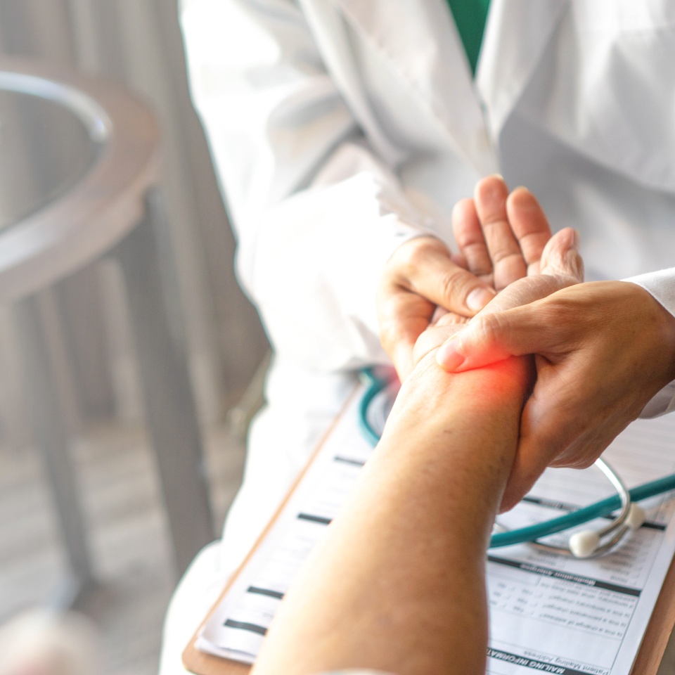 Doctor holds and examines a patient's wrist, focusing on providing accurate diagnosis and care.Professional medical attention, trust, and the importance of addressing wrist pain or injury.