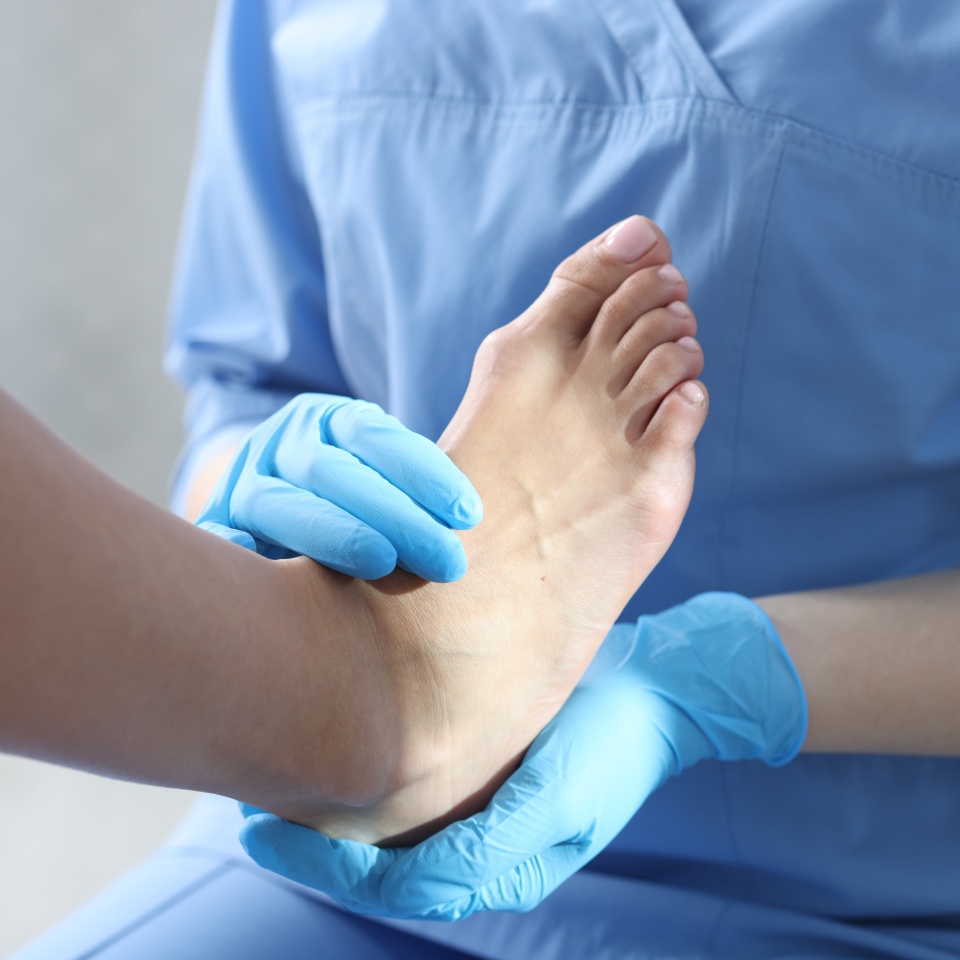 Doctor examining patient's foot in hospital, closeup