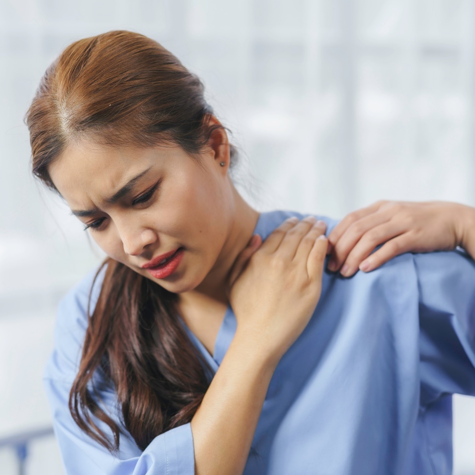 Compassionate female physician providing shoulder pain relief, supporting patient during medical examination