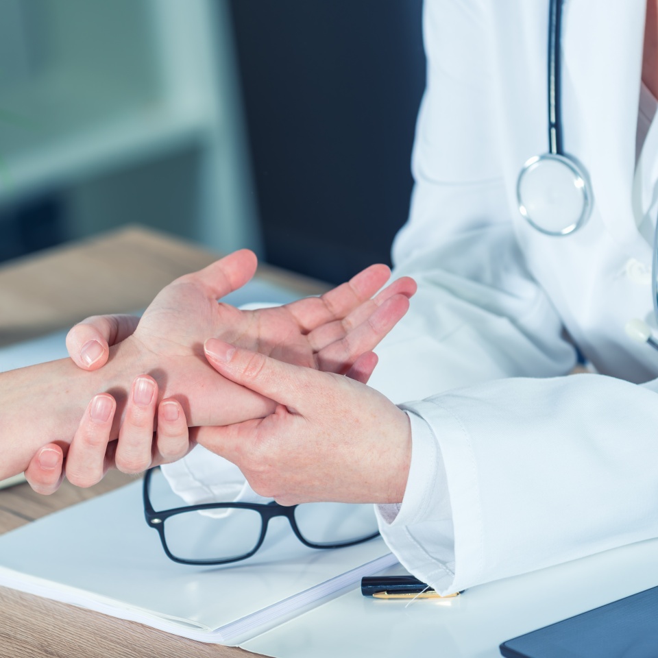 Female patient at orthopedic medical exam in doctor's hospital office, traumatology and medical consultation for hand wrist injury