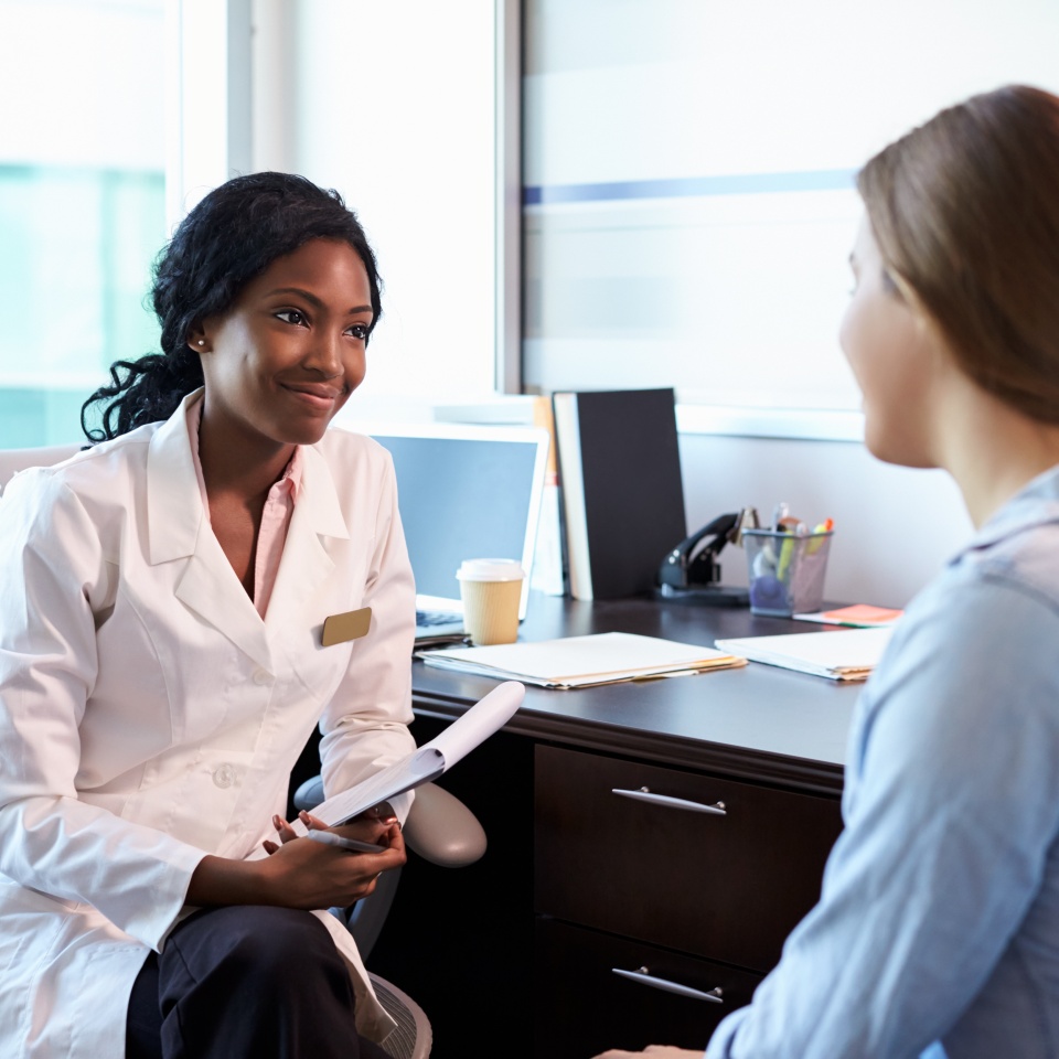 Doctor In Consultation With Female Patient In Office