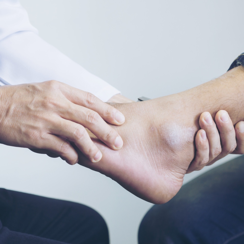 Doctor the traumatologist examines the leg examined at the medical office