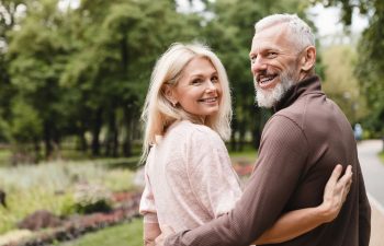 Cheerful senior couple chatting while walking in a park