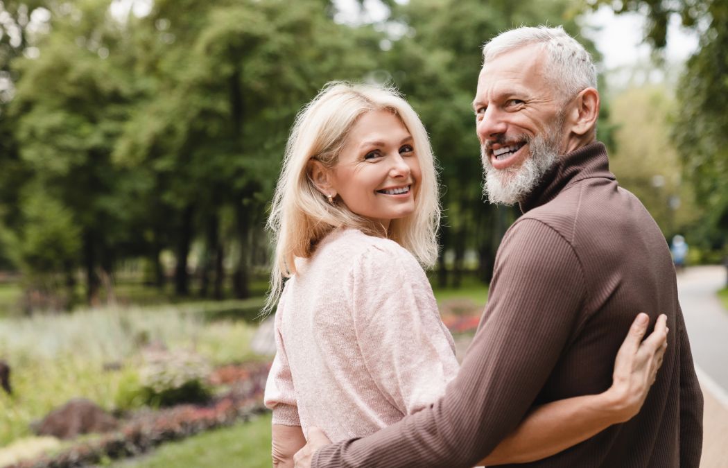 Cheerful senior couple chatting while walking in a park