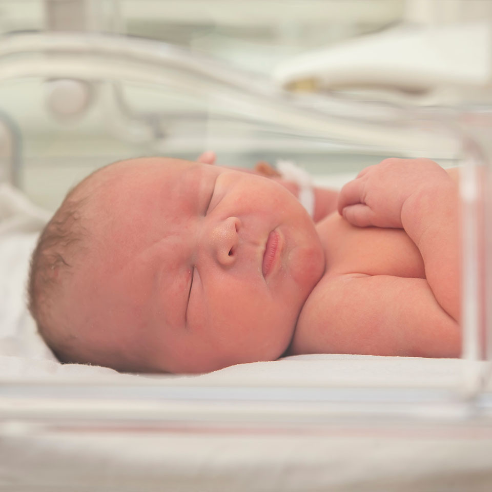 Newborn baby in an incubator for babies